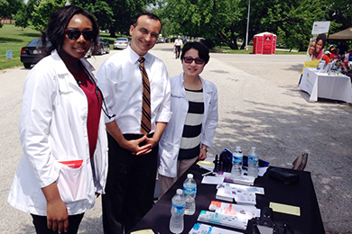Dr. Daniel Mansour appears at a health fair alongside two other members of the Lamy Center team.