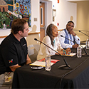 Three people speak on a panel.